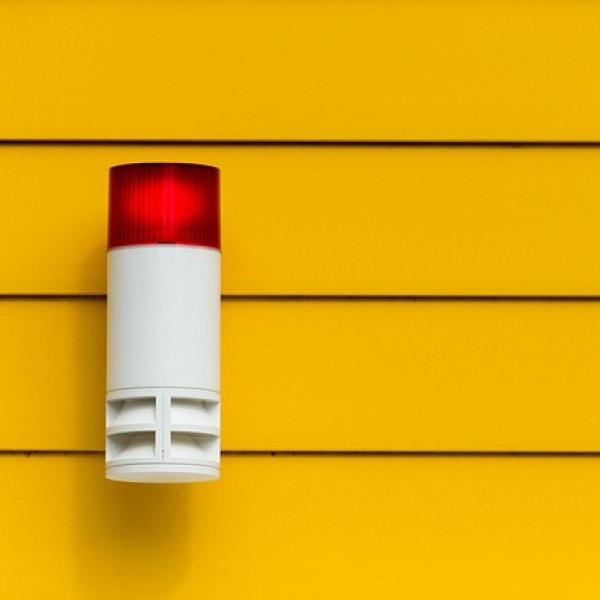 Luz roja de una alarma con un fondo de pared amarilla