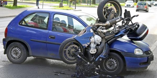 Moto accidentada sobre un coche de color azul