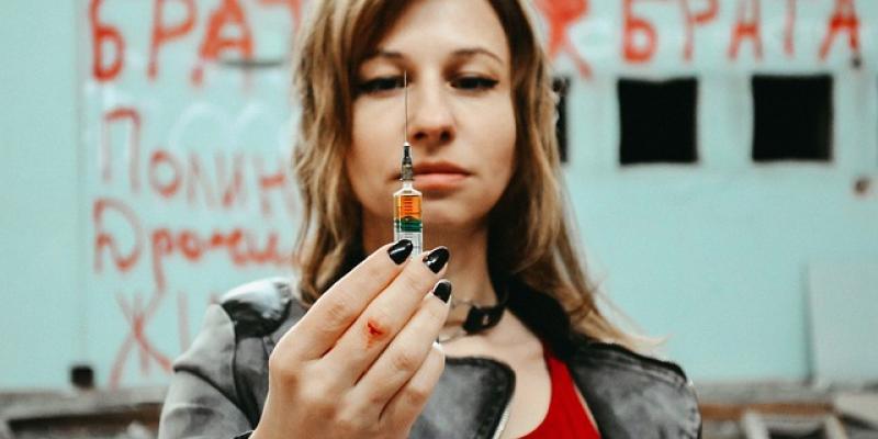 Chica joven sosteniendo una jeringuilla