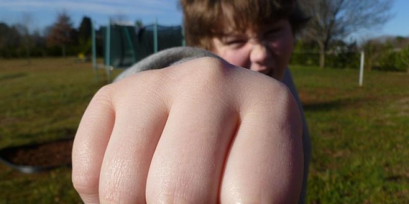 Puño de un chico intentando realizar una agresión