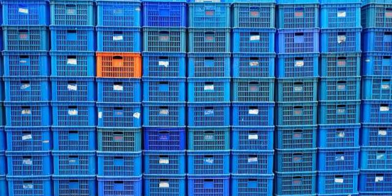 Cajas de plástico azul apiladas en un almacén