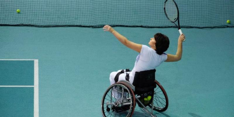 Persona en silla de ruedas jugando al tenis