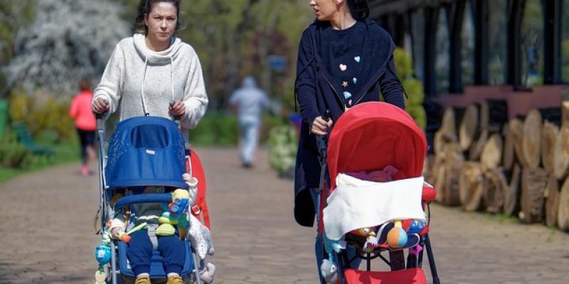 Dos madres paseando a sus bebés