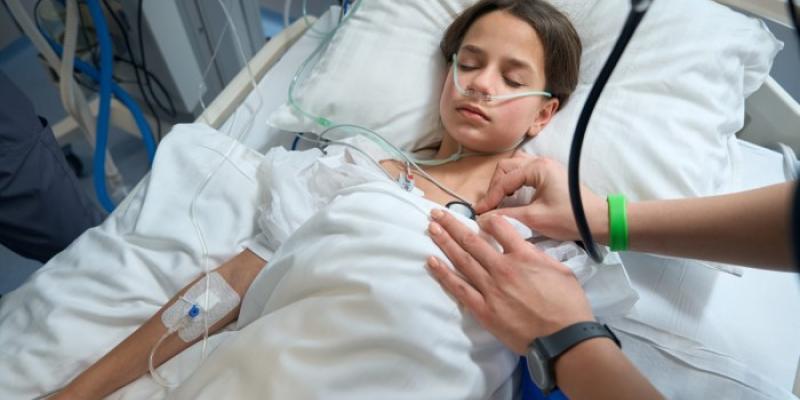 Una enfermera controla las constantes de una niña semiinconsciente 