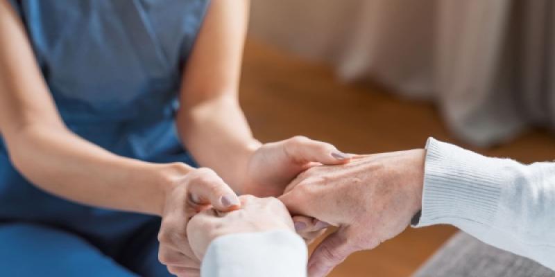 Manos de una persona dependiente y su cuidadora