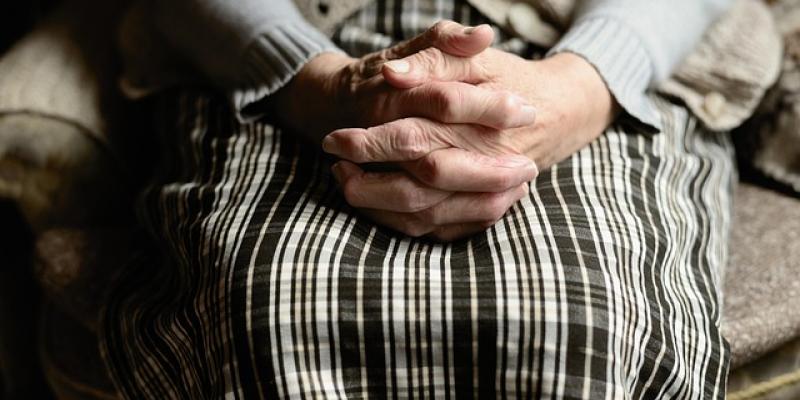 Manos de una persona mayor sobre su regazo