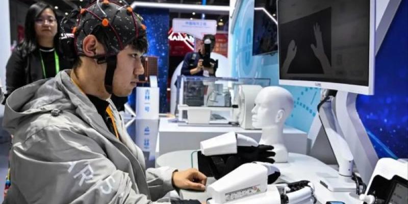 Un hombre muestra una mano robótica con interfaz cerebro-computadora
