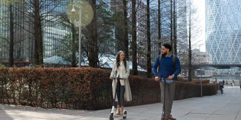 Dos trabajadores en patinete