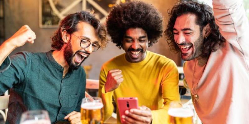 Amigos celebrando que han ganado apuestas deportivas en línea
