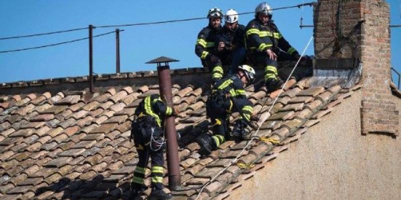 Bomberos italianos colocando la chimenea que tras el cónclave anunciara si hay nuevo Papa