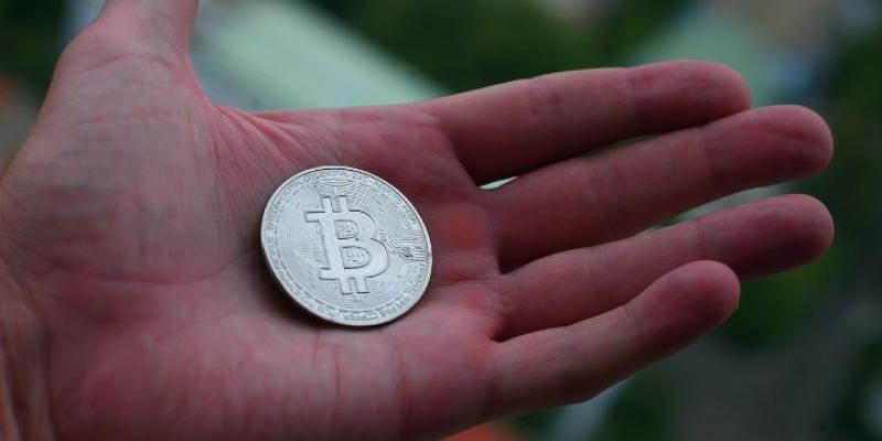 Mano de una persona con una criptomoneda