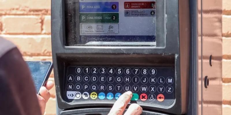 Una persona utiliza un parquímetro, en Madrid.