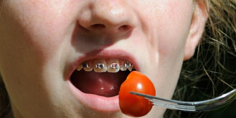 Una niña con ortodoncia se come un tomate 'cherry'