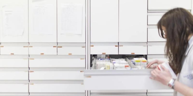 Una trabajadora busca fármacos en una farmacia. 