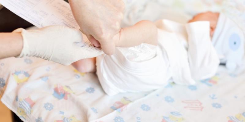 Una enfermera realiza la prueba del talón a un bebé 