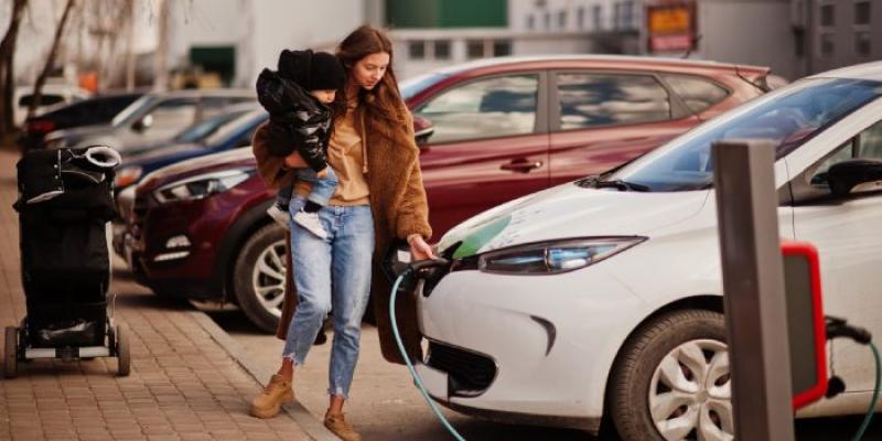 Mujer cargando vehículo eléctrico 
