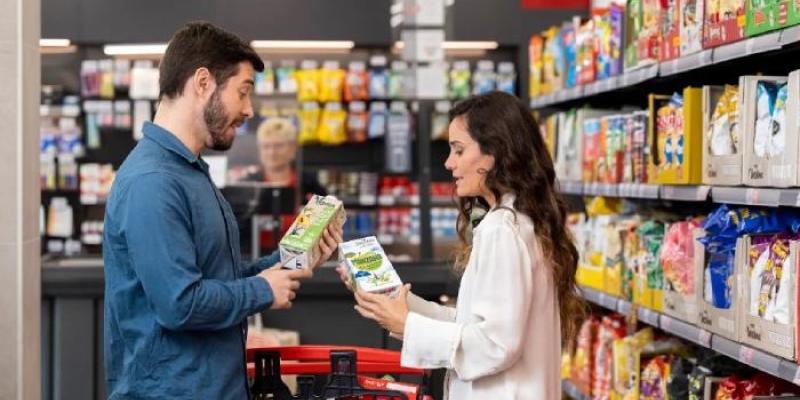 Dos jóvenes, comparando precios en un supermercado