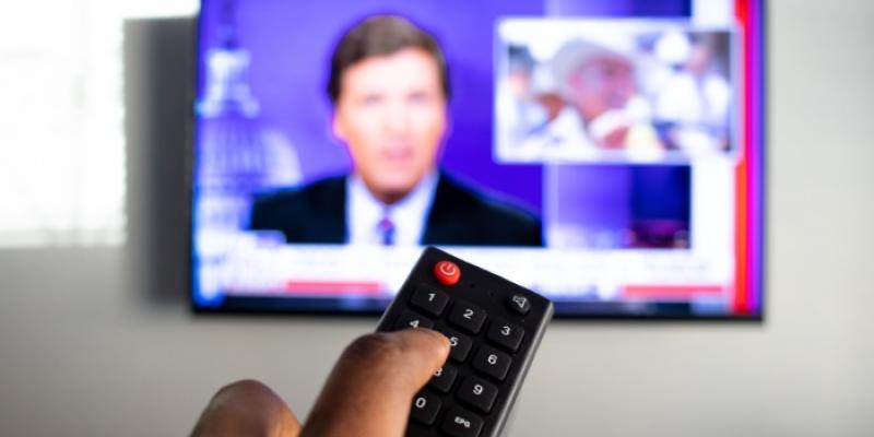 Persona pulsando el mando de la televisión