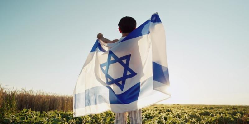 Feliz niño judío israelí saltando, bandera nacional de Israel. Día de la Independencia. Patriotismo. Símbolo de democracia, independencia y futuro. 