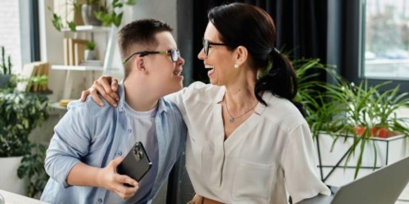 Un chico con discapacidad riendo con su mentora empresarial