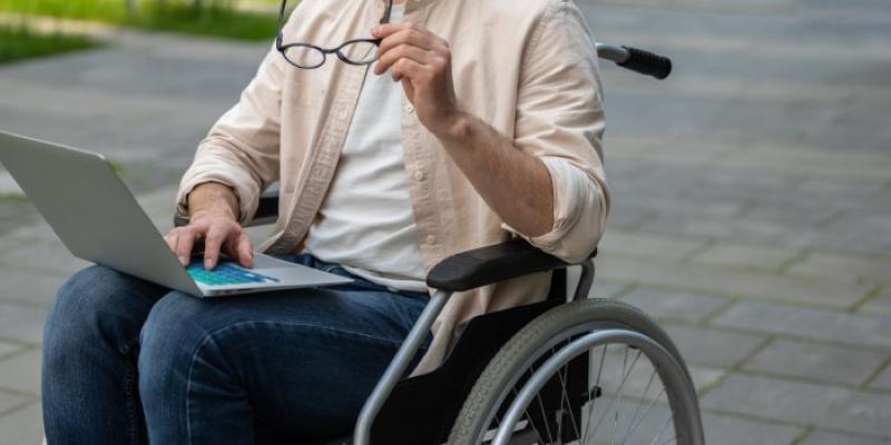Un estudiante en silla de ruedas consulta su ordenador 