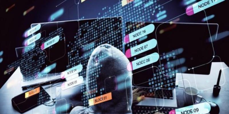 Representación de un 'ciberdelincuente' frente a unas pantallas