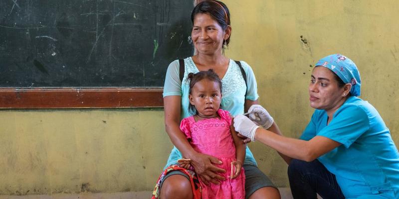 Una niña de dos años recibe la vacuna contra la gripe en un dispensario móvil de Loreto, Perú.