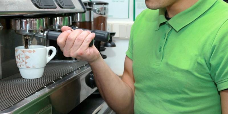 Empleado de hostelería poniendo un café