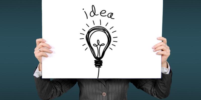 Persona sujetando un cartel en el que puede leerse "idea"