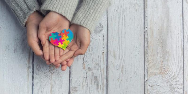 Unas manos unidas, con un dibujo de un corazón