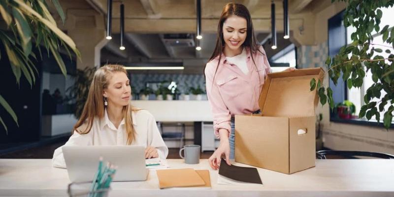 Dos chicas en la oficina recogiendo sus cosas en cajas