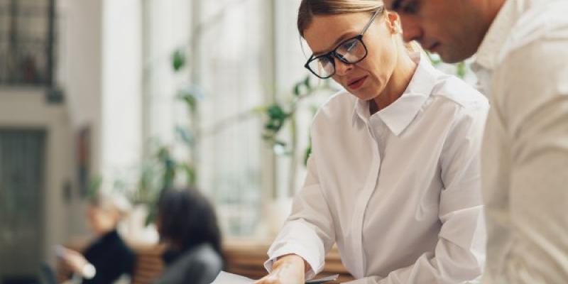 Dos colegas que trabajan juntos en el plan de negocios durante la jornada laboral en la oficina. 