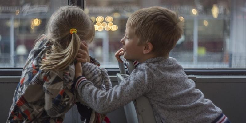 Dos niños mirando por una ventana