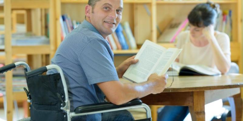 Un hombre con discapacidad, en la biblioteca de una universidad