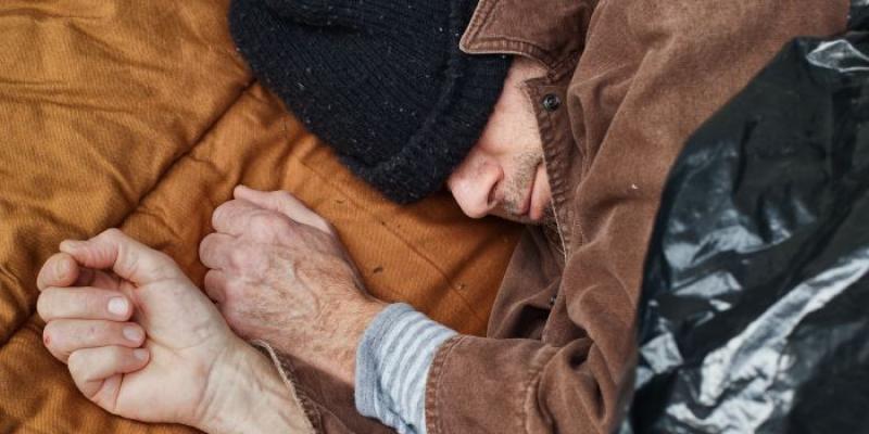 Un hombre sin vivienda duerme en el suelo