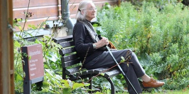 Señora mayor con demencia sentada en un banco