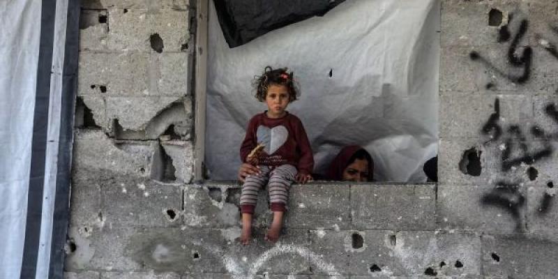 Se ve a una niña mientras palestinos examinan los escombros del edificio completamente derrumbado y buscan objetos utilizables tras un ataque aéreo llevado a cabo por el ejército israelí contra una casa perteneciente a la familia Abdulhadi en la ciudad de Khan Yunis, en el sur de la Franja de Gaza, el 6 de abril de 2025.