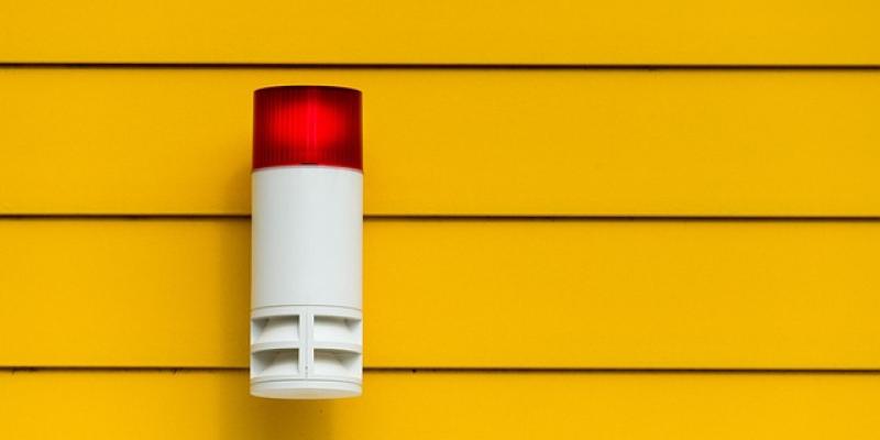 Luz roja de una alarma con un fondo de pared amarilla