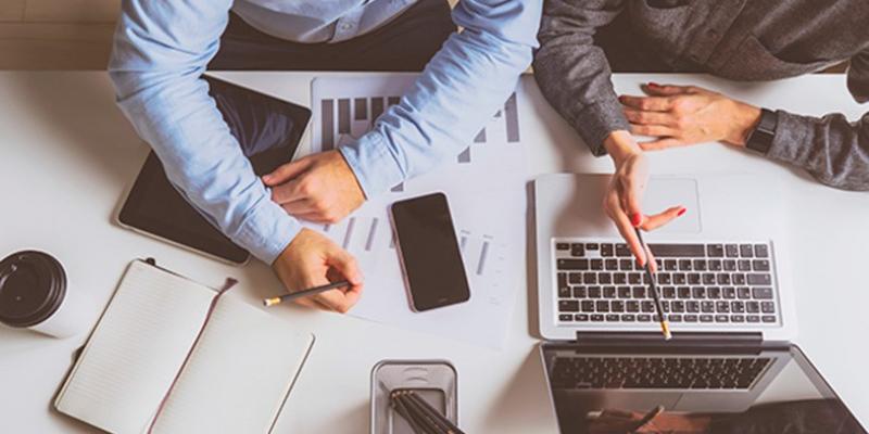 Dos personas trabajando en una pyme con sus ordenadores