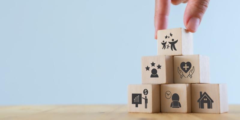 Imagen con cubos de madera formando una torre y la mano de una chica