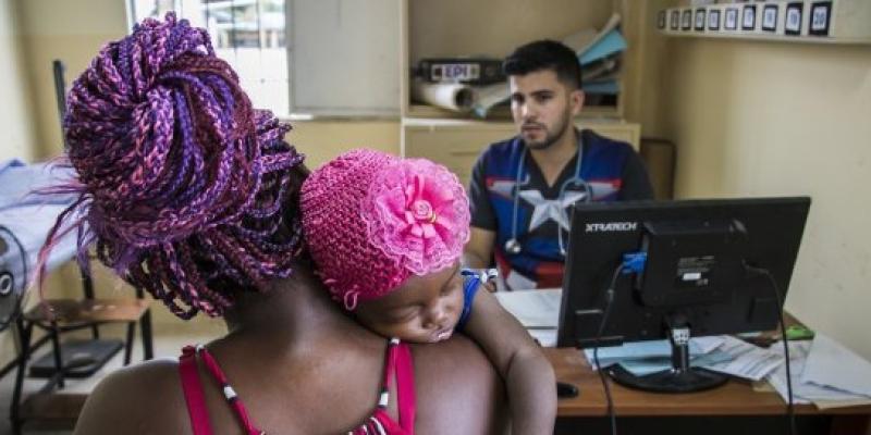 Un médico atiende a una madre y su bebé en Ecuador.