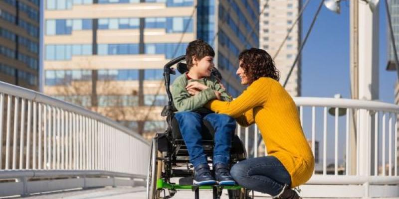 Una madre pasea por la ciudad con su hijo con parálisis cerebral 