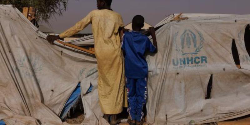 Dos niños, que vienen de un grupo de refugiados de la región de Darfur en Sudán, dan un vistazo por encima de una de las tiendas de ayuda humanitaria del campamento de Adre, en Chad, el pasado 19 de abril de 2024.