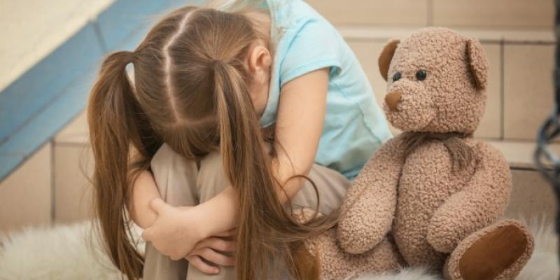 Una niña se abraza en un gesto triste 