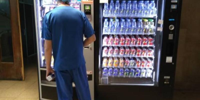 Un trabajador de un hospital frente a una máquina de 'vending' 