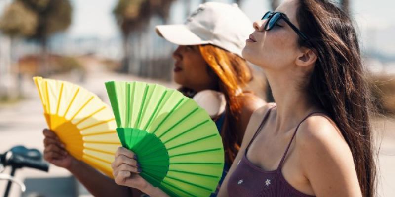 Dos personas se abanican para contrarrestar las altas temperaturas 