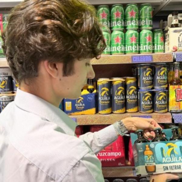 Joven comprando cerveza en el supermercado