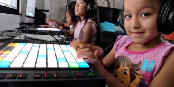Niña utilizando las nuevas tecnologías en el ámbito de la cultura / NdP 21distritos