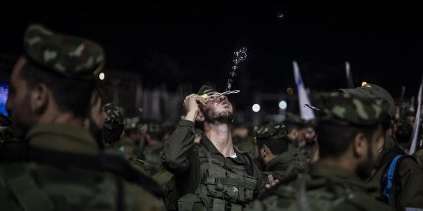 Soldado israelí jugando con pompas de jabón en el muro de las lamentaciones en Jerusalén.
