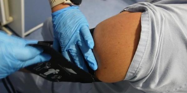 Un médico comprueba la tensión arterial de un paciente.